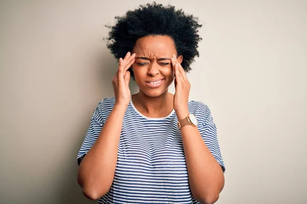 ストレスが原因で頭の痛みのために頭の上に手で縞模様のTシャツを着て巻き毛を持つ若い美しいアフリカ系アメリカ人アフロ女性 片頭痛に苦しむ — ストック写真