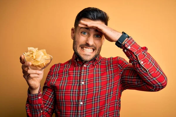 Young Handsome Man Holding Bowl Potato Chips Isolated Yellow Background — Stock Photo, Image