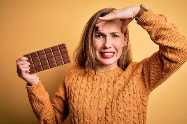 Junge Schöne Blonde Frau Mit Schokoriegel Vor Isoliertem Gelben Hintergrund — Stockfoto