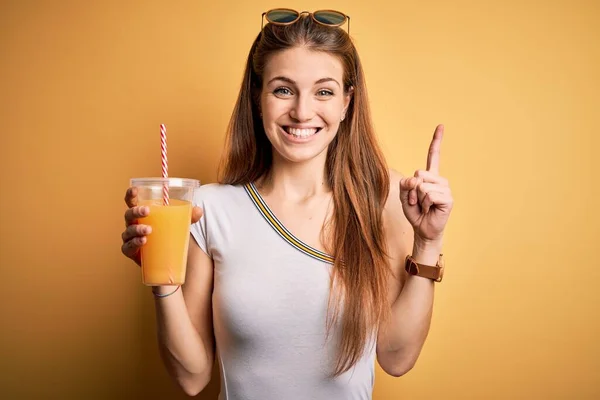 Junge Schöne Rothaarige Frau Trinkt Gesunden Orangensaft Auf Gelbem Hintergrund — Stockfoto