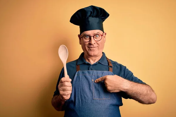 앞치마를 숟가락을 중년의 요리사가 얼굴로 자신을 가리키며 — 스톡 사진