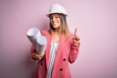 Güvenlik kaskı takan genç, güzel, esmer bir mimar elinde planları olan bir kadın bir fikir ya da soru işareti ile şaşırdı.