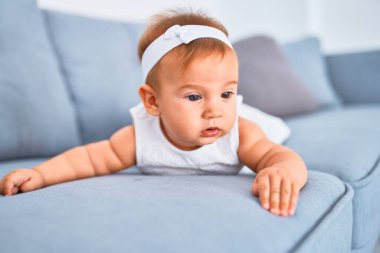 Evdeki kanepede uzanmış sevimli bir bebek. Yeni doğmuş bebek rahatlıyor ve dinleniyor.