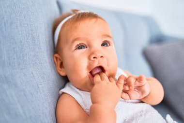 Evdeki kanepede uzanmış sevimli bir bebek. Yeni doğmuş bebek rahatlıyor ve dinleniyor.