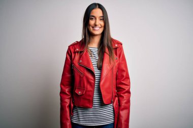 Genç, güzel esmer kadın, sıradan çizgili tişört ve yüzünde mutlu ve havalı bir gülümseme olan kırmızı ceket giyiyor. Şanslı kişi..