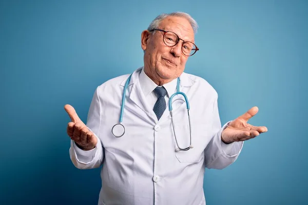 Starszy Siwy Lekarz Noszący Stetoskop Płaszcz Medyczny Niebieskim Tle Nieświadomy — Zdjęcie stockowe