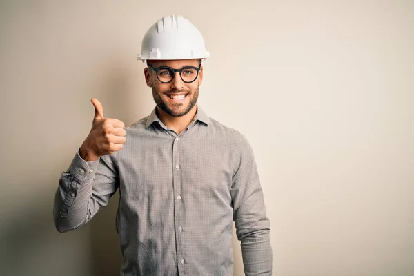 年轻的建筑师 戴着建筑工人安全帽 带着孤独的背景 手举着快乐的大拇指 在镜头前看着成功的表情 — 图库照片