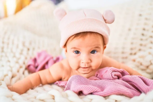 自宅のソファの上に毛布の上に寝そべっている愛らしい赤ちゃん 新生児を身に着けているファニー帽子リラックスして休息快適な — ストック写真