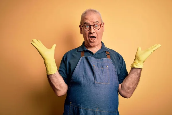 Middle Age Cleaner Man Cleaning Wearing Apron Gloves Isolated Yellow — Stock Photo, Image