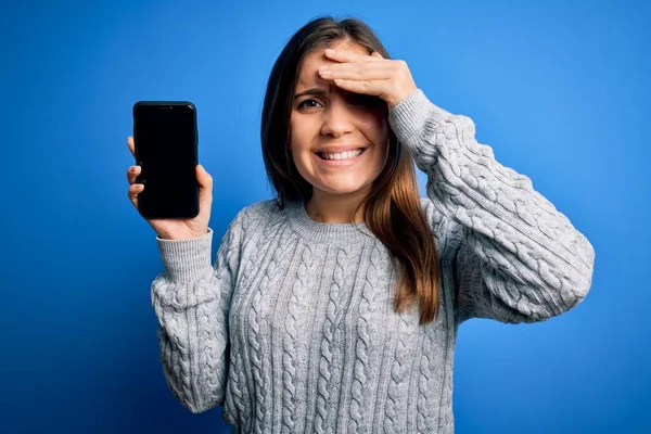 Jovem Mostrando Tela Smartphone Branco Sobre Fundo Isolado Azul Estressado — Fotografia de Stock