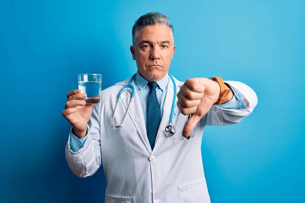 Średni Wiek Przystojny Siwowłosy Lekarz Człowiek Pijący Szklankę Wody Niebieskim — Zdjęcie stockowe
