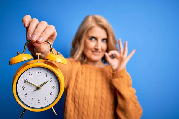 Middle Age Beautiful Blonde Woman Holding Vintage Alarm Clock Blue — Stock Photo, Image