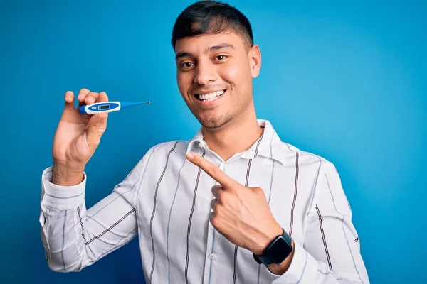 Jeune Homme Hispanique Tenant Thermomètre Température Médicale Sur Fond Bleu — Photo