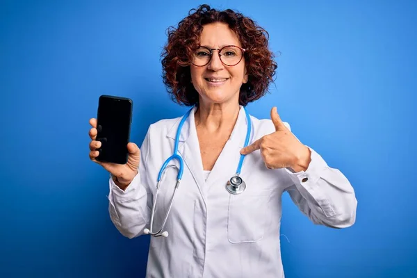 Médico Meia Idade Mulher Vestindo Casaco Estetoscópio Segurando Smartphone Mostrando — Fotografia de Stock