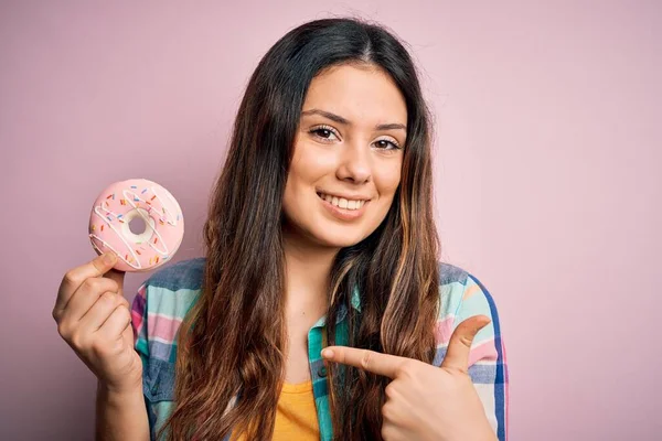 Joven Hermosa Morena Comiendo Donut Rosa Dulce Sobre Fondo Aislado — Foto de Stock