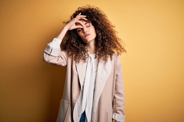 Young beautiful brunette woman with curly hair and piercing wearing casual t-shirt and diadem tired rubbing nose and eyes feeling fatigue and headache. Stress and frustration concept.