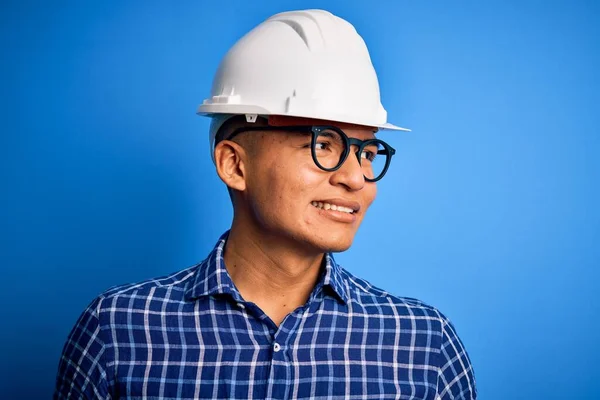 年轻英俊的工程师拉汀 头戴安全帽 面带微笑 神态自然地望向一边 充满自信的笑 — 图库照片