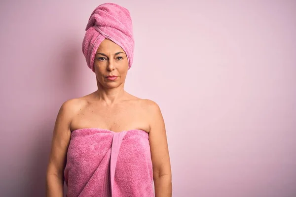 Middle age woman wearing bath towel from beauty body care over pink background depressed and worry for distress, crying angry and afraid. Sad expression.