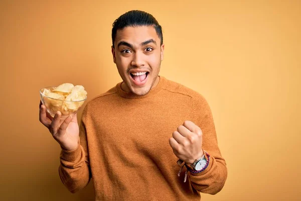 Young Brazilian Man Holding Bowl Chips Potatoes Isolated Yellow Background — Stock Photo, Image