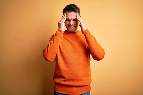 오렌지 스웨터 잘생긴 청년은 스트레스 때문에 머리에 통증을 느끼기 위에서 — 스톡 사진