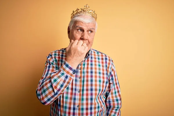 배경에 왕관을 나이많고 잘생긴 남자가 손톱을 물어뜯는 손으로 스트레스와 긴장을 — 스톡 사진