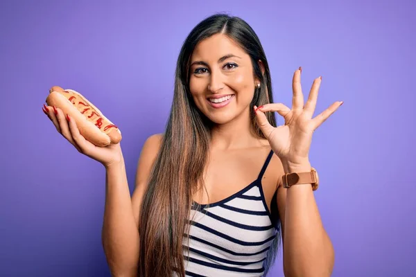 Ung Kvinna Äter Korv Med Ketchup Och Senap Över Lila — Stockfoto