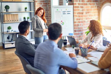 Group of business workers working together in a meeting. One of them making presentation to colleagues at the office