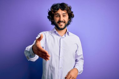 Mor arka planda duran sakallı yakışıklı iş adamı dostça bir selamlama ve hoş geldin hediyesi olarak gülümsedi. Başarılı bir iş..