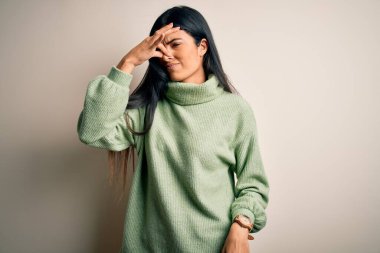 İzole edilmiş arka planda yeşil süveter giyen genç, İspanyol bir kadın pis ve iğrenç bir koku alıyor. Dayanılmaz bir koku. Parmakları burnunda nefesini tutuyor. Kötü kokuyor.