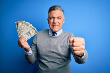 Orta yaşlı, yakışıklı, gri saçlı, elinde bir deste dolar olan bir adam. Sinirli ve sinirli. Öfkeyle bağırıyor, çıldırıyor ve el kaldırarak bağırıyor.