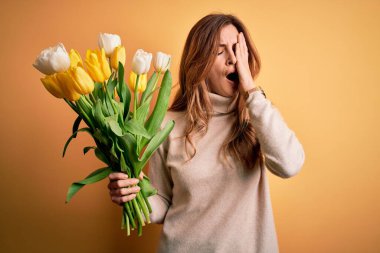 Genç, güzel esmer kadın, izole edilmiş arka planda sarı lale buketi tutuyor. Yarı yüz, göz ve ağız ile esnemekten yorgun düşüyor. Yüzüm acıyor..