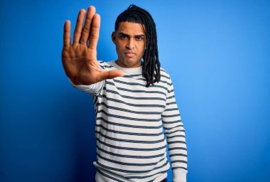 Rastgele çizgili süveter giyen Afro-Amerikan genç yakışıklı adam avucuyla şarkı söylemeyi kesiyor. Yüzünde olumsuz ve ciddi bir jest olan uyarı ifadesi.