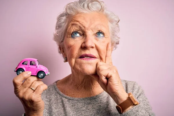 Senior Beautiful Woman Holding Small Car Standing Isolated Pink Background — Stock Photo, Image