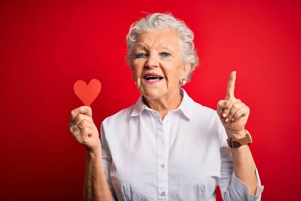 Senior Mooie Vrouw Met Papieren Hart Staande Geïsoleerde Rode Achtergrond — Stockfoto