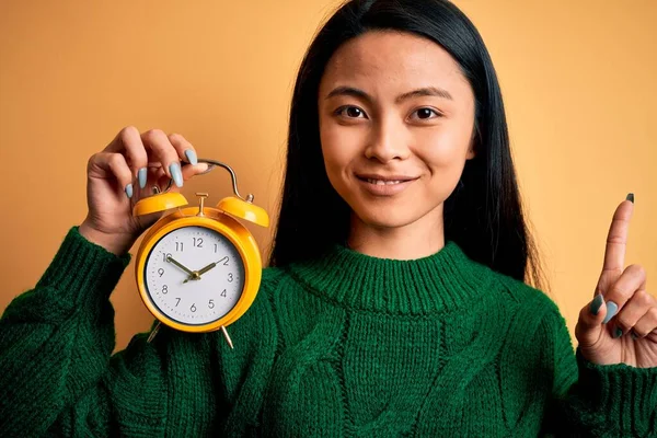 Jeune Belle Femme Chinoise Tenant Réveil Vintage Sur Fond Jaune — Photo