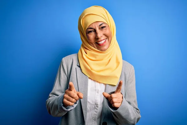 中年黑发女商人 头戴穆斯林传统头巾 头戴蓝色背景的头巾 手指指向镜头 脸上洋溢着欢乐滑稽的表情 好的能量和活力 — 图库照片