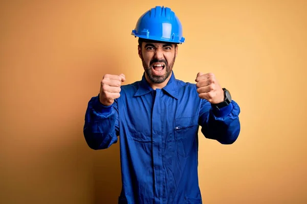 Mechaniker Mit Bart Blauer Uniform Und Schutzhelm Vor Gelbem Hintergrund — Stockfoto