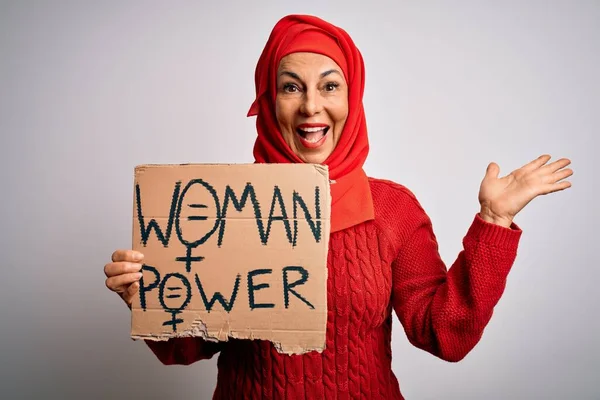 ムスリムヒジャーブを身に着けている中年女性が女性の権利を求めるバナーを保持非常に幸せと興奮 大きな笑顔で叫んで勝利を祝う勝者式と手を上げ — ストック写真