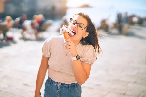 休暇中の若い美しい女性が幸せと自信を笑顔 顔に笑顔で立ち市内を歩くアイスクリームを食べる — ストック写真
