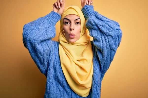 年轻美丽的黑发穆斯林女子 头戴阿拉伯头巾 头戴黄铜头巾 做着滑稽的手势 头戴牛角 — 图库照片