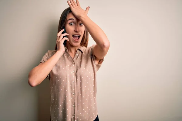 Ung Vacker Kvinna Som Pratar Smartphone Över Vit Bakgrund Överraskad — Stockfoto