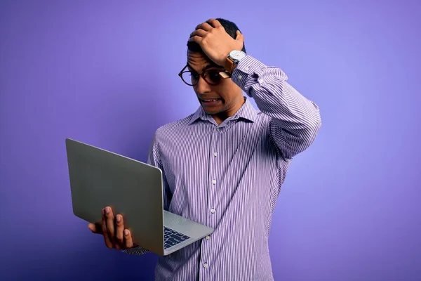 若いハンサムなアフリカ系アメリカ人のビジネスマンの頭の上に手で強調紫色の背景にノートパソコンを使用して作業し 恥と驚きの顔でショックを受け 怒りと不満 恐怖と過ちへの動揺 — ストック写真