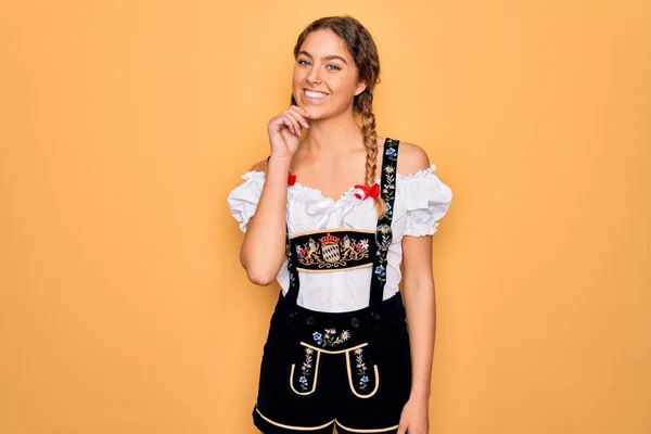 年轻美丽的金发德国女人 蓝眼睛 穿着传统的十月节礼服 看着相机 满心自信地微笑着 双臂交叉 双手托着下巴 积极地思考 — 图库照片