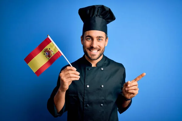 Joven Guapo Cocinero Con Barba Vistiendo Uniforme Sosteniendo Bandera Española — Foto de Stock