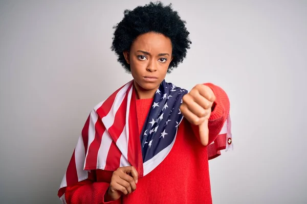 Young African American afro woman with curly hair wearing united states of america flag with angry face, negative sign showing dislike with thumbs down, rejection concept