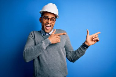 Genç ve yakışıklı Afro-Amerikan mühendis. Rastalı güvenlik kaskı takmış. Gülümsüyor ve kameraya bakıyor..