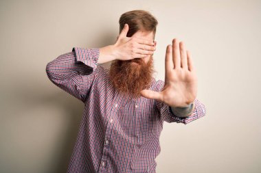 Yakışıklı İrlandalı kızıl saçlı, sakallı, gözlüklü, soyutlanmış arka planda, gözleri ellerle kaplayan, üzgün ve korku ifadeli hareketler yapan bir iş adamı. Utanç verici ve olumsuz bir kavram..