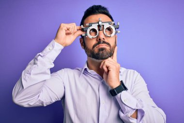Mor arka planda optometri gözlüğü takan yakışıklı, optik bir adam.