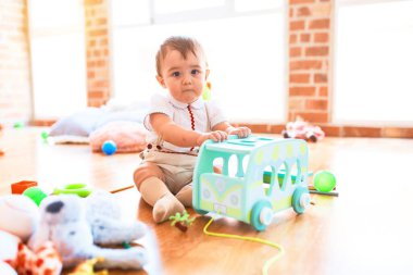 Anaokulunda bir sürü oyuncakla oynayan sevimli bir çocuk.
