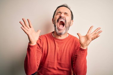 Orta yaşlı, turuncu süveter giyen, izole edilmiş beyaz arka planda dikilmiş, çılgın ve çılgın bir başarıyı kolları havada ve gözleri kapalı, heyecanlı bir şekilde kutlayan, orta yaşlı bir adam. Kazanan konsept